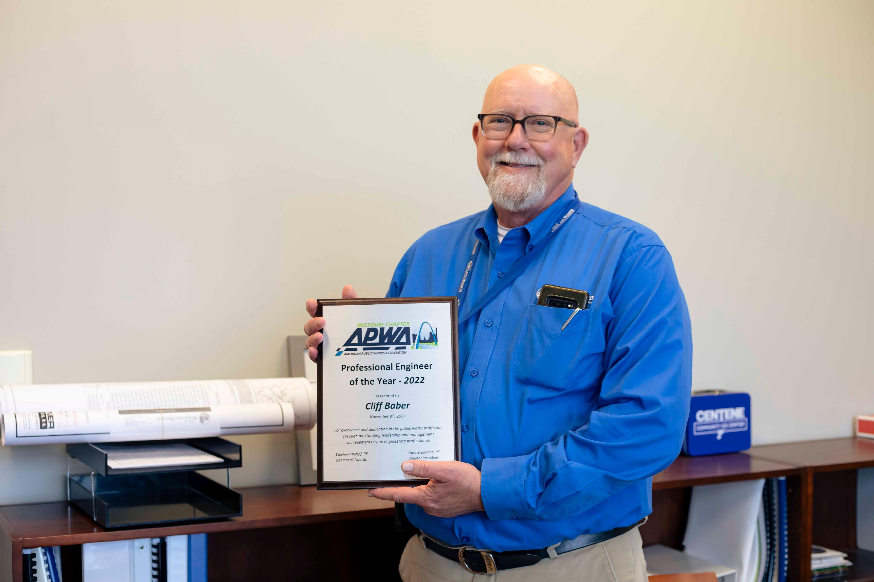 Maryland Heights Director of Public Works Cliff Baber smiles and holds a trophy from the Missouri chapter of the American Public Works Association declaring him the 2022 Professional Engineer of the Year
